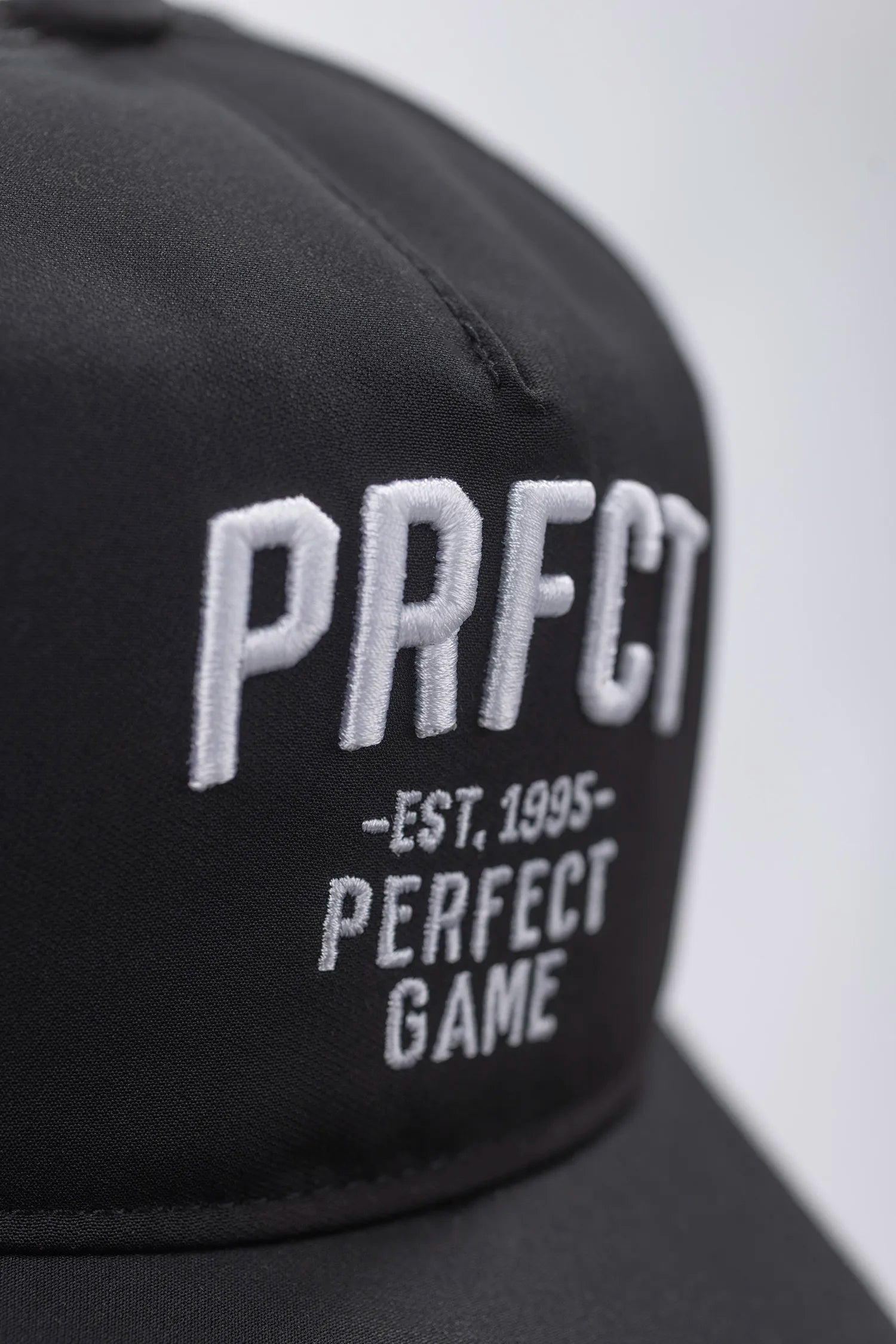 Black cap with 'PRFCT EST. 1995 PERFECT GAME' text on a white background